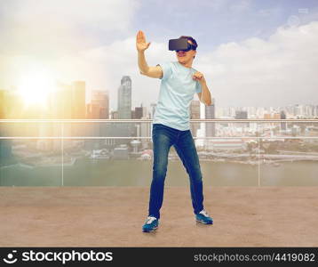 3d technology, virtual reality, entertainment, cyberspace and people concept - young man with virtual reality headset or 3d glasses playing game and fighting over singapore city skyscrapers background