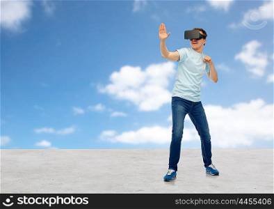 3d technology, virtual reality, entertainment, cyberspace and people concept - young man with virtual reality headset or 3d glasses playing game and fighting over blue sky and clouds background