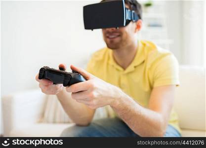 3d technology, virtual reality, gaming, entertainment and people concept - close up of happy young man with virtual reality headset or 3d glasses playing video game with controller gamepad at home