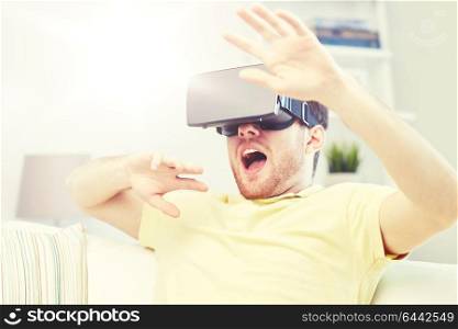 3d technology, virtual reality, gaming, entertainment and people concept - scared young man with virtual reality headset or 3d glasses playing game. young man in virtual reality headset or 3d glasses
