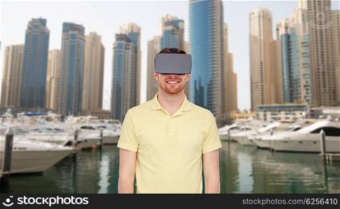 3d technology, virtual reality, travel, entertainment and people concept - happy young man with virtual reality headset or 3d glasses over dubai city street background