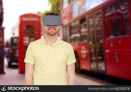 3d technology, virtual reality, travel, entertainment and people concept - happy young man with virtual reality headset or 3d glasses over london city street background