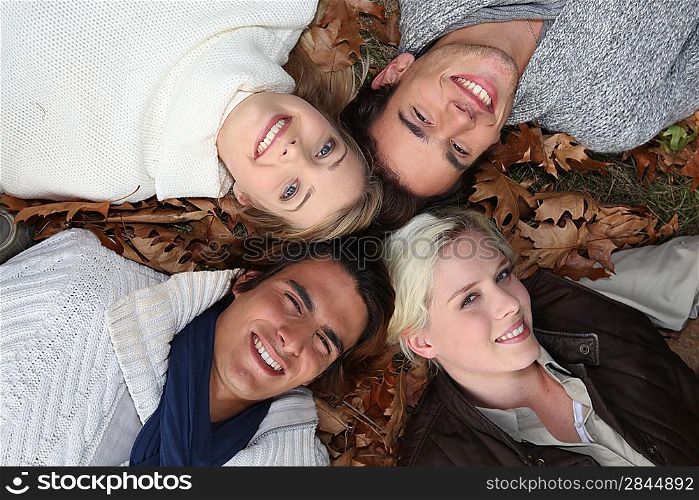 4 young people heads in the grass at autumn