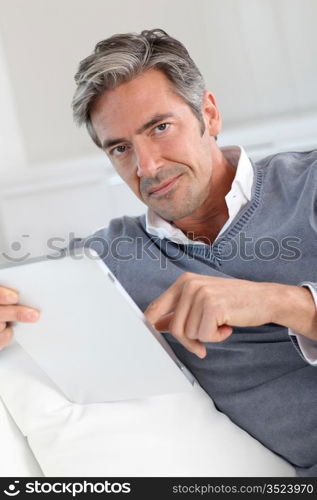 40-year-old man at home using electronic tablet