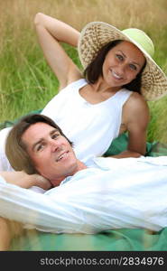 40 years old man and woman relaxing and lying down in a meadow