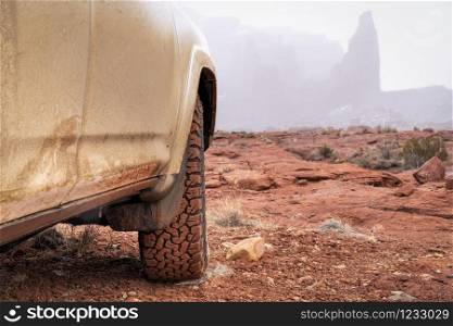 4x4 SUV car or truck driving on a trail in winter conditions - Fisher Towers in Moab area, Utah, off-road driving, recreation and travel concept
