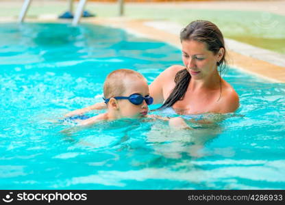 5 years old boy learning to swim with mom