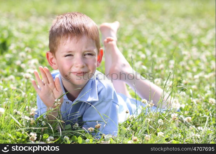 5 years old child lying on the grass.