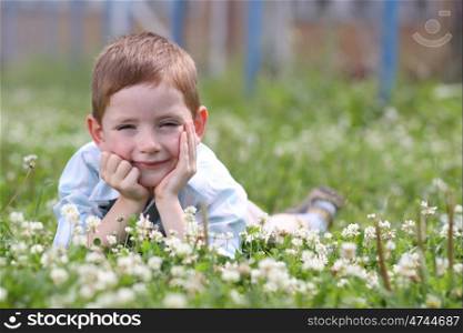 5 years old child lying on the grass.