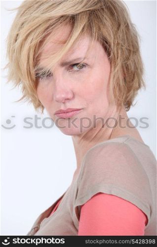 50 years old woman with tousled hair looks anger or in trouble