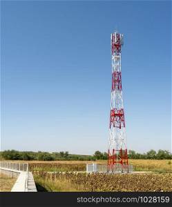 5G antenna for high speed internet distribution. 5G repeaters outside the city. Bright colours red and white.