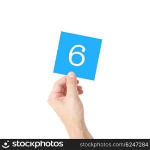 6 written on a card held by a hand