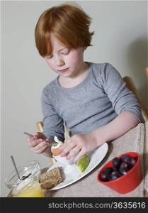 7-8 year old sits eating boiled egg