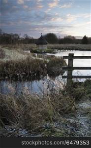 71918610 - beautiful landscape on winter morning of eel traps over flowing river in english countryside