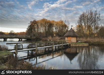 71945829 - beautiful landscape on winter morning of eel traps over flowing river in english countryside