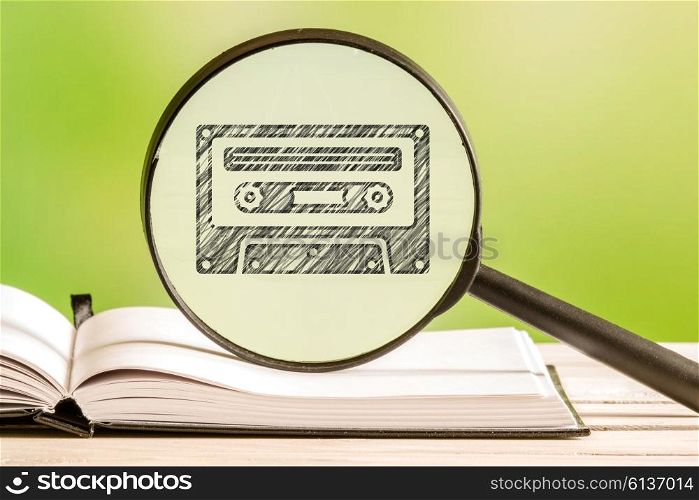 80s music information with a pencil drawing of a cassette tape in a magnifying glass