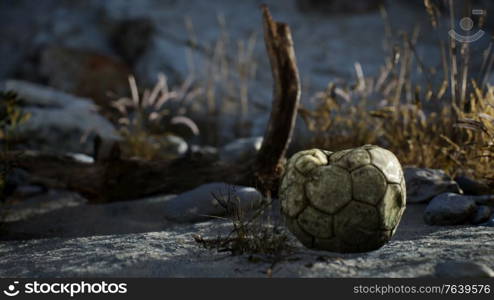 8K old torn soccer ball thrown lies on sand of sea beach