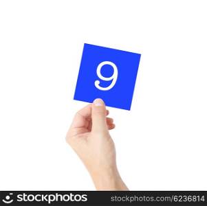9 written on a card held by a hand