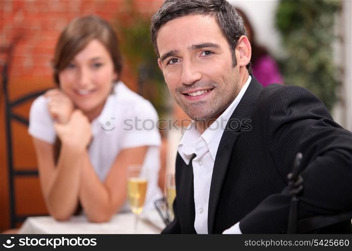 a 40 years old man and a 16 years old girl with sparkling wine on a restaurant table