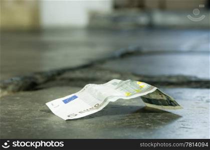 A 5 euro banknote lying on a church floor