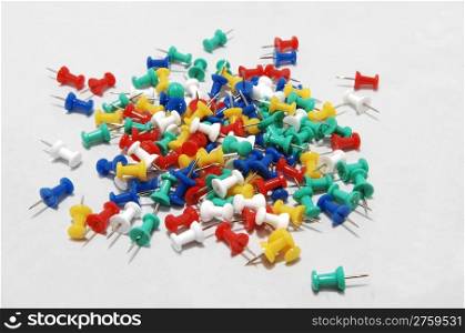 A assortment of colorful push-pins for office or home use on lightgray background.