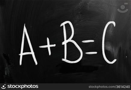 ""A+B=C" handwritten with white chalk on a blackboard"