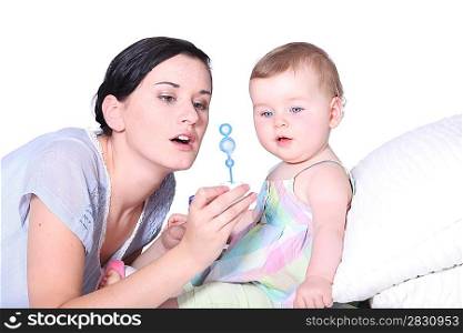 a baby and her mother looking a soap bubble solution