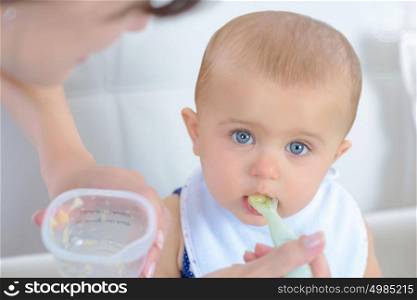 a baby eating with mother