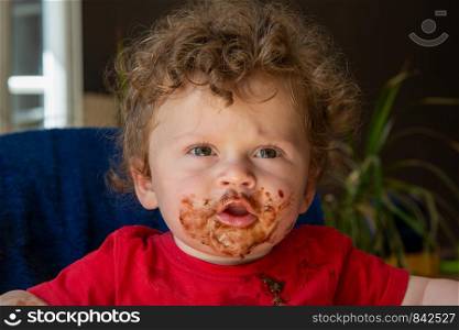a baby is eating a chocolate cake