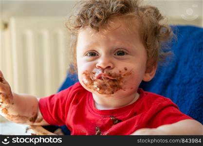 a baby is eating a chocolate cake