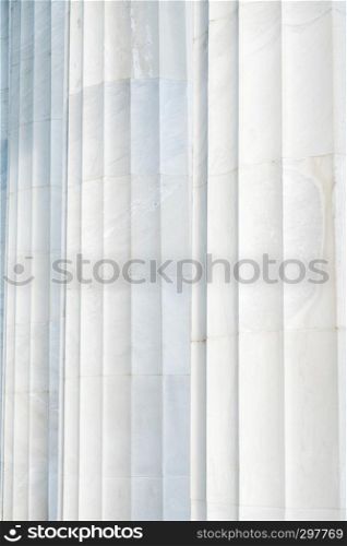 A background that shows the subtle coloring and the fluting on three white marble columns at the Lincoln Memorial in Washington DC.