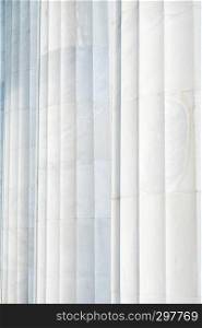 A background that shows the subtle coloring and the fluting on three white marble columns at the Lincoln Memorial in Washington DC.