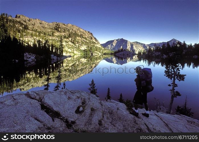 A backpacker stops at an outcropping that overlooks Looking Glass Lake, in the Eagle Cap Wilderness, Northeast Oregon