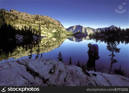 A backpacker stops at an outcropping that overlooks Looking Glass Lake, in the Eagle Cap Wilderness, Northeast Oregon