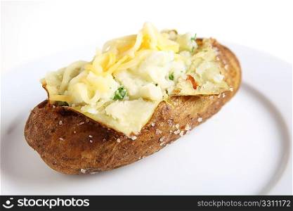 A baked burbank russet or Idaho potato, filled with parsley creamed potato and topped with grated cheese, on a white plate providing space for text