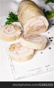 A baked chicken roll on the white cutting board