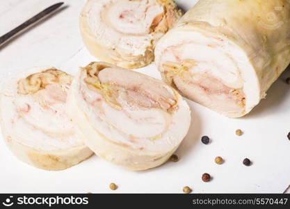 A baked chicken roll on the white cutting board