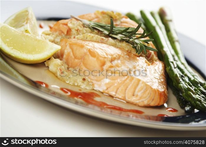 A baked stuffed salmon with asparagus on the side