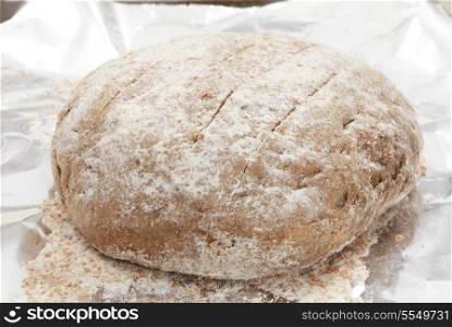 A ball of Polish rye bread dough rising on a sheet of tinfoil on a baking tray,