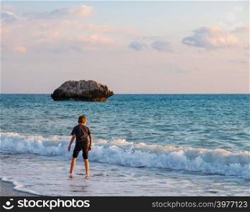 A barefooted boy plays at the beach at the Petra tou Romiou rocks, in Paphos, Cyprus. The beach is considered to be Aphrodite&rsquo;s birthplace in Greek mythology.