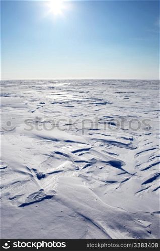 A barren winter landscape of snow and ice,