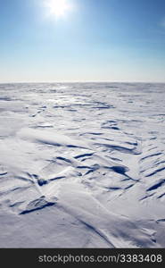 A barren winter landscape of snow and ice,