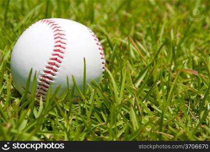 A baseball on a grassy green ballpark.