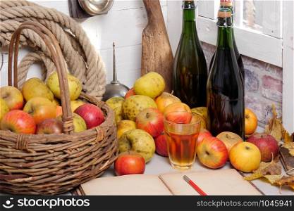a basket of apples, bottles of cider and old notebook