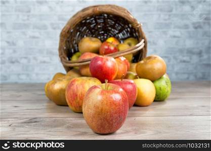 a basket of apples spilled on the table