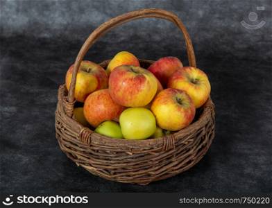 a basket with red and yellow apples