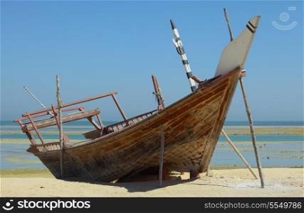 A beached dhow at Wakrah, south of Doha, Qatar. The vessel seems to have been abandoned long ago and is little more than a wreck now