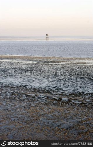 A beacon in the Westerschelde, the Netherlands at low tide on a clear winter day