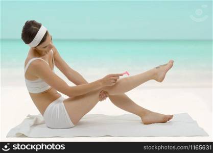 a beautiful adult caucasian woman shaving legs with razor