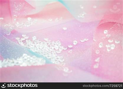 A beautiful and elegant macro of glitter from sparkling diamonds with bokeh or depth of field and pink texture as background